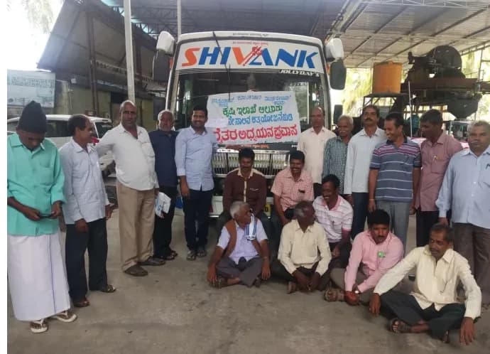 Farmers gathered at a community meeting beside a delivery truck